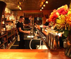 Bartender pouring a draft beer with flowers in the foreground